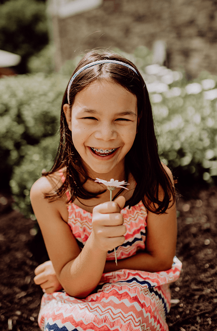 Girl with braces holding flower